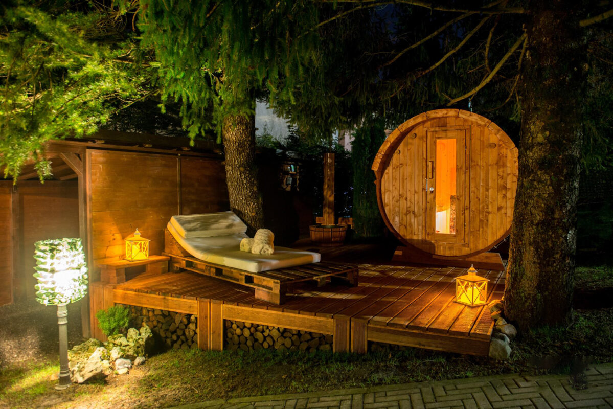 Neptune Saunas and hot tubs - wooden barrel sauna in customers garden at night time