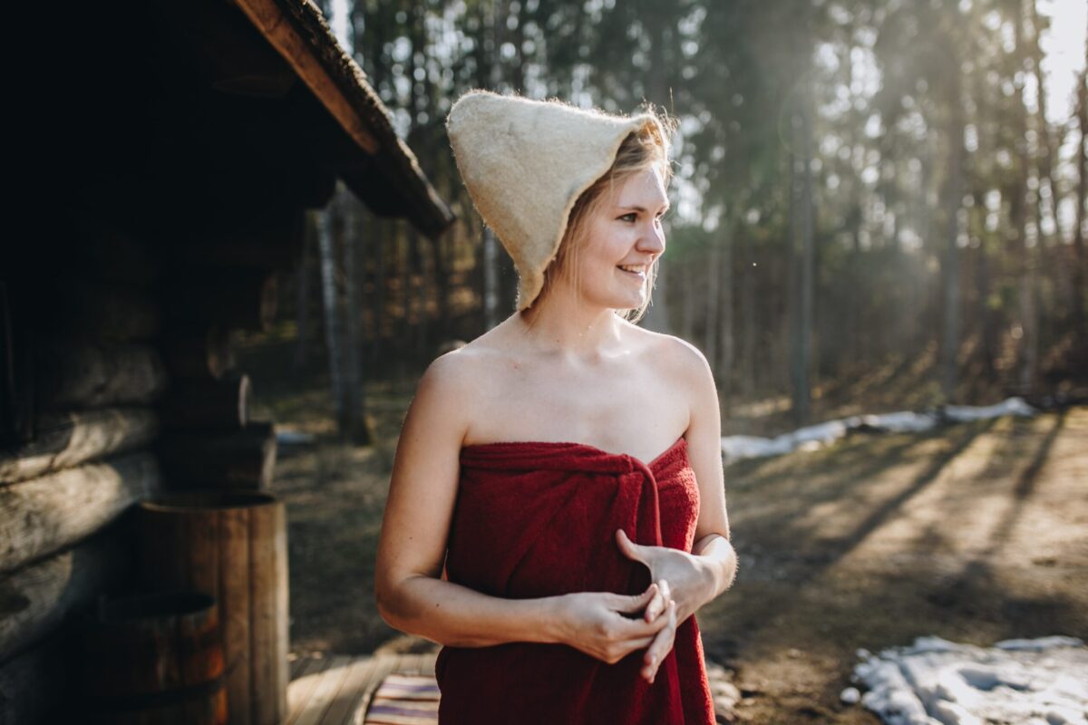 Neptune Saunas Blog - How to protect your hair in a sauna - estonian woman wearing a sauna hat in the forest